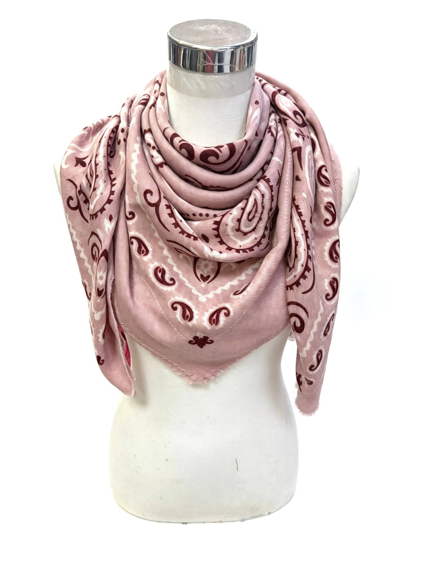 A dusty pink square scarf with a dark red paisley pattern, draped on a white mannequin torso against a white background.