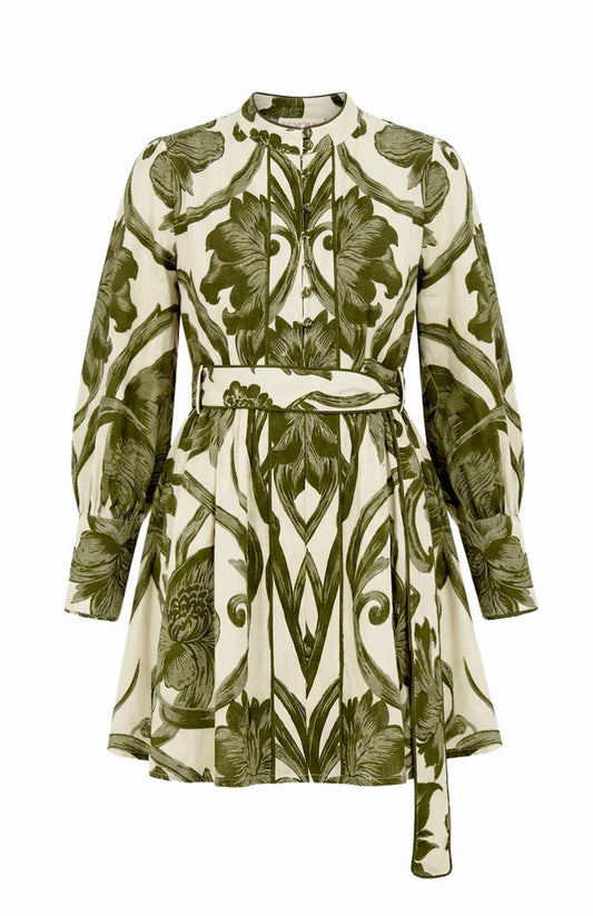 A long-sleeve mini dress with a high mock neck and a self-tie belt, featuring an all-over botanical and scroll pattern in olive green on a warm cream background.