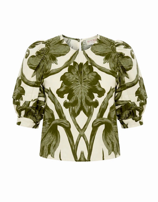 A women's blouse with a symmetrical, mirrored floral print in olive green on an off-white background, featuring puffed 3/4 sleeves and a round neckline.
