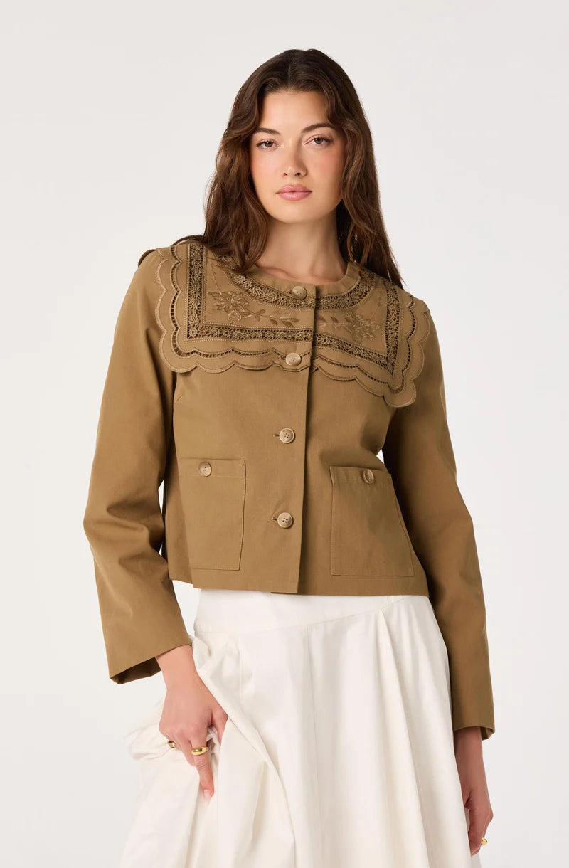 Woman wearing a brown jacket with lace details on a white background