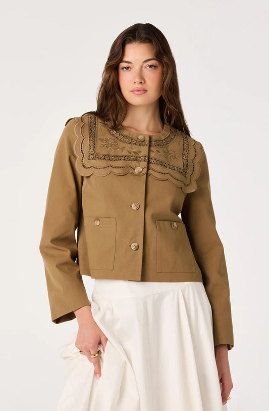 Woman wearing a brown jacket with lace details on a white background