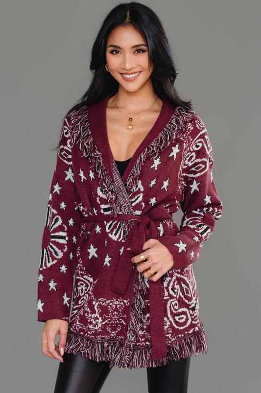 Woman wearing a burgundy patterned robe against a gray background