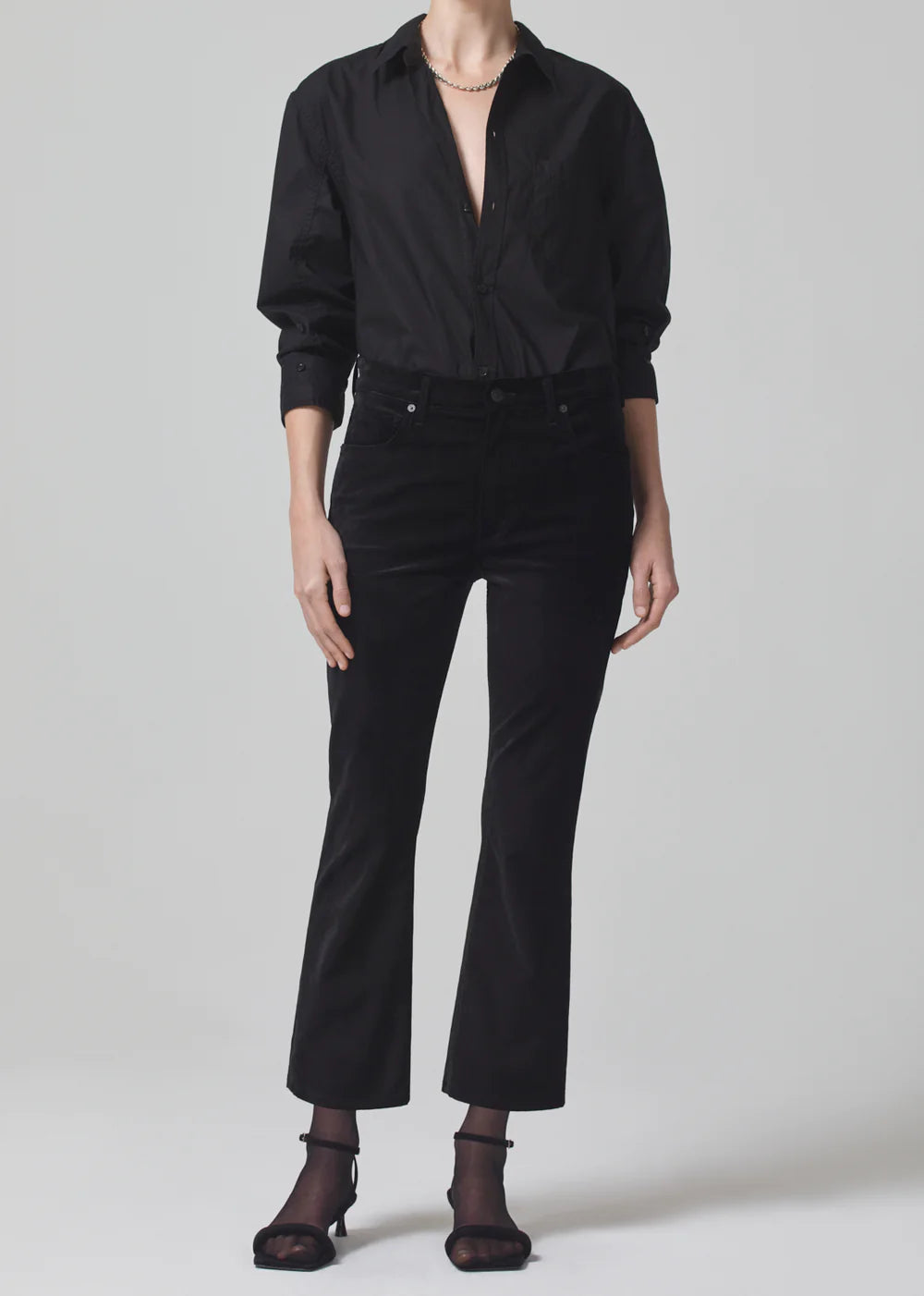 Person wearing a black shirt and black pants on a white background