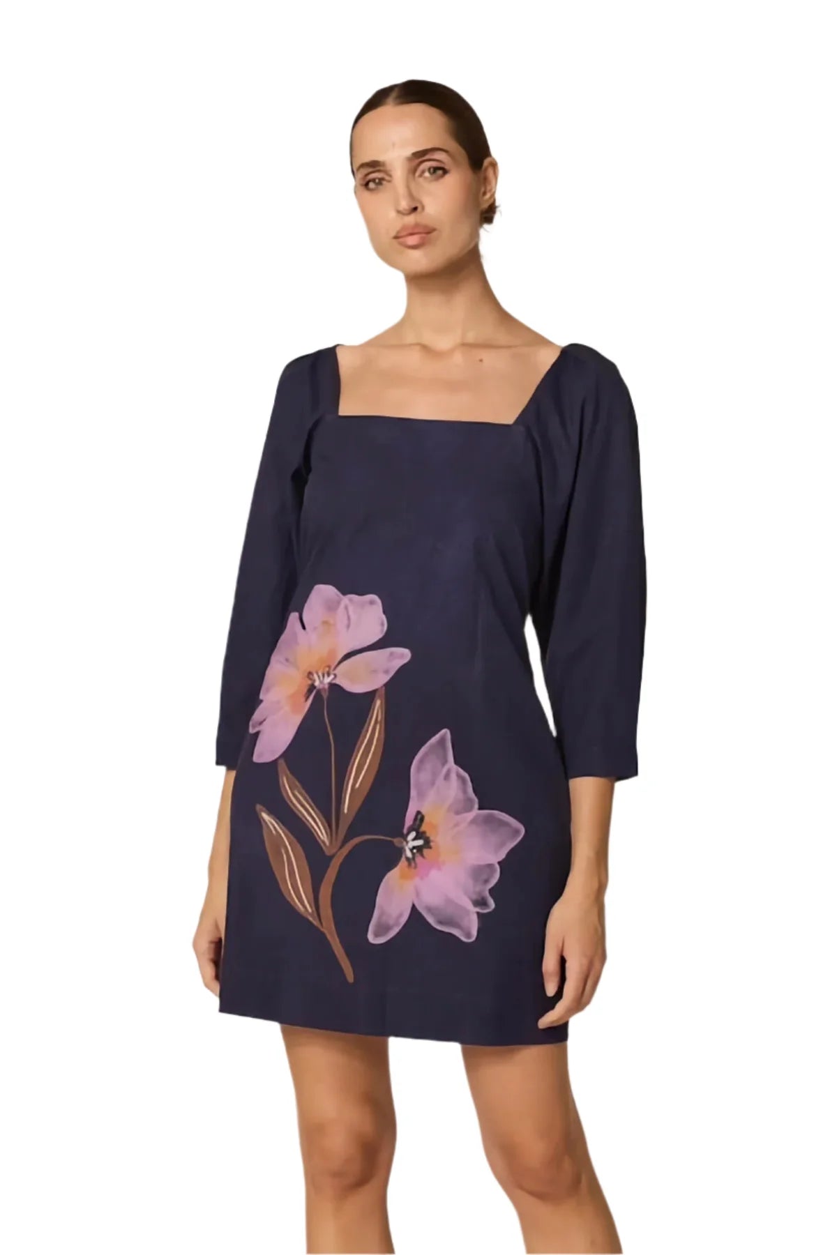 Woman wearing a navy dress with floral designs on a white background