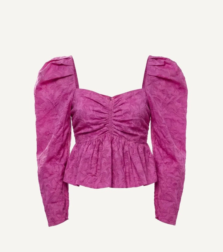 Purple top with puff sleeves on a light gray background