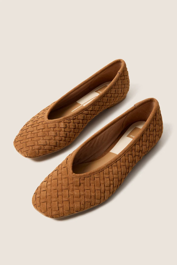 Pair of brown woven flat shoes on a light beige background