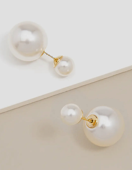 Pearl earrings with gold accents on a light background