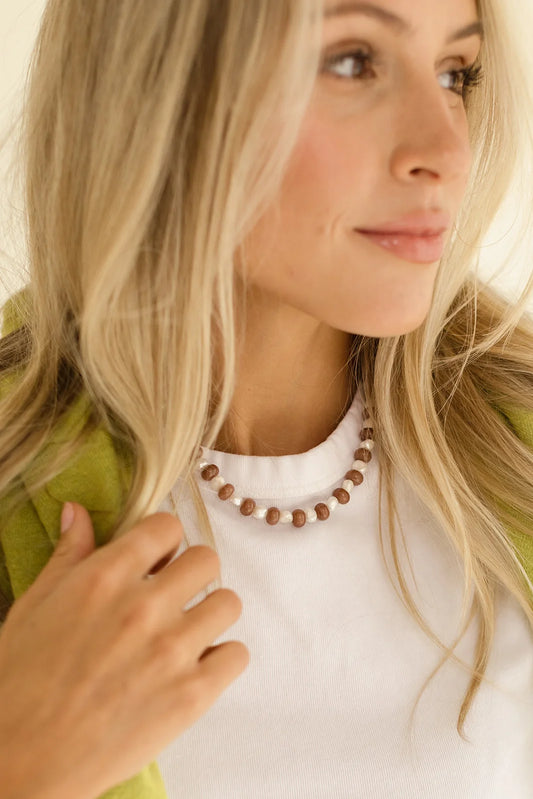 Woman wearing a necklace with a blurred background