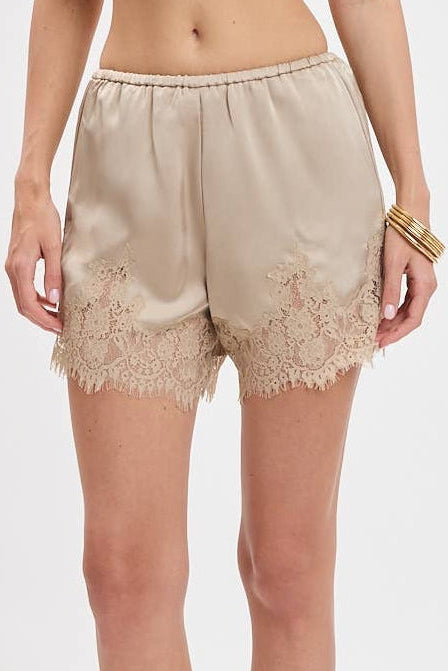 Beige satin shorts with a lace hem, shown on a model against a plain white background.