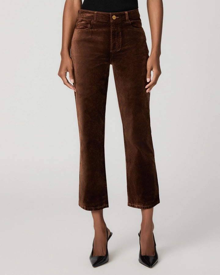 A model wearing brown cropped corduroy pants with a straight-leg fit, paired with black pointed-toe heels, shown against a light gray studio background.