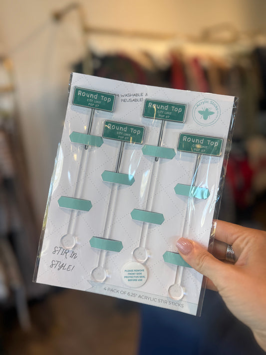 Packaged set of round-top acrylic stir sticks held by a hand with a blurred background.