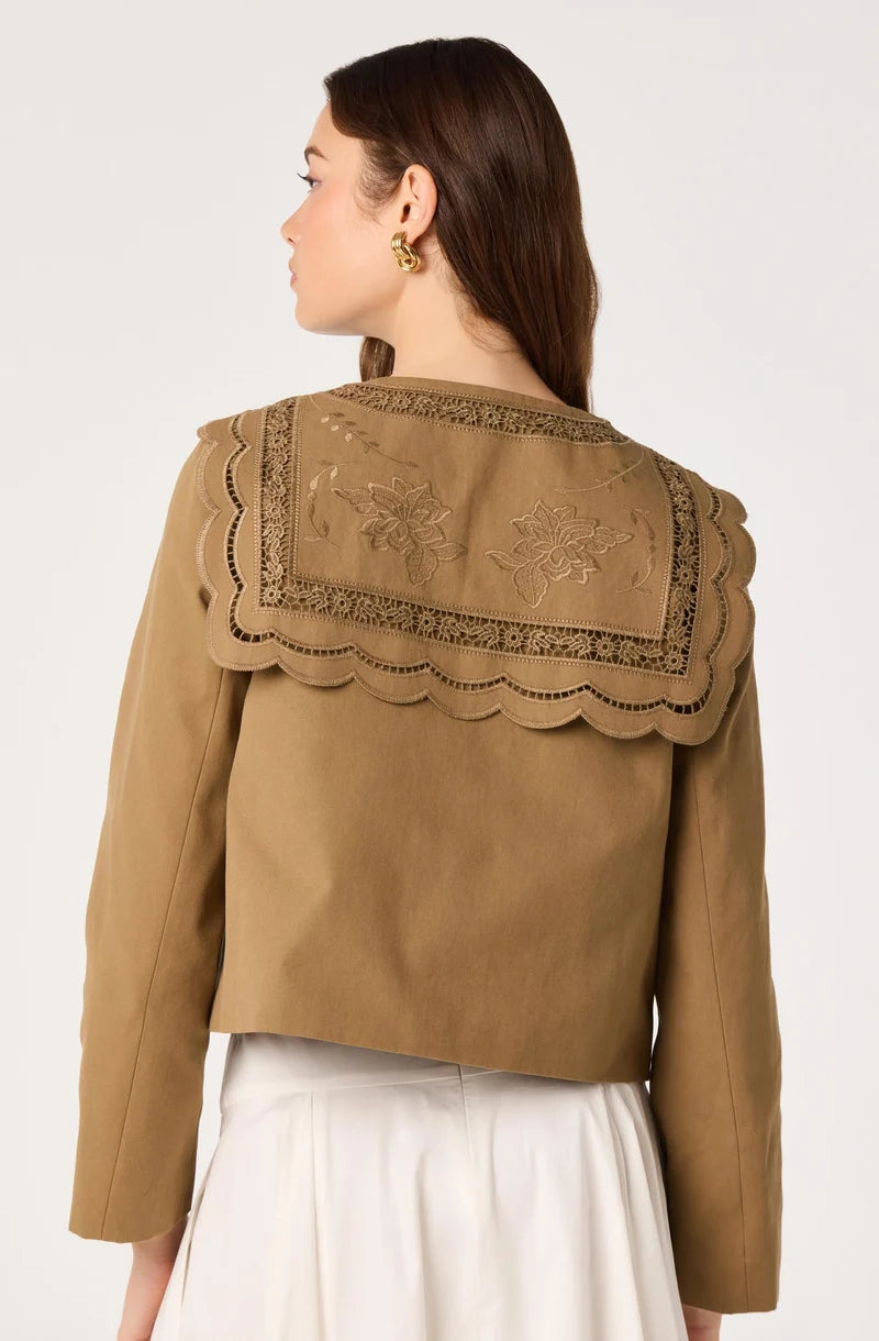 Woman wearing a brown jacket with lace details on a white background