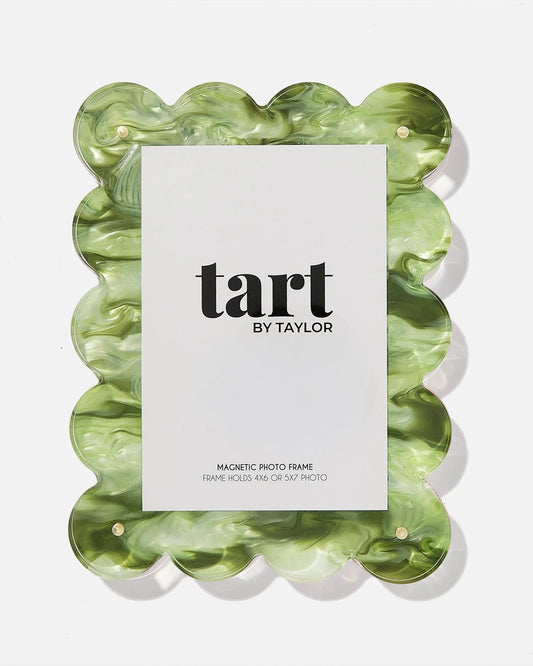 A scalloped-edge magnetic photo frame made of marbled green and white resin, shown with a white insert card displaying the brand name 'tart BY TAYLOR' on a clean white background.