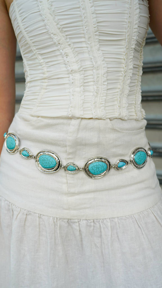 White dress with a turquoise belt featuring silver accents