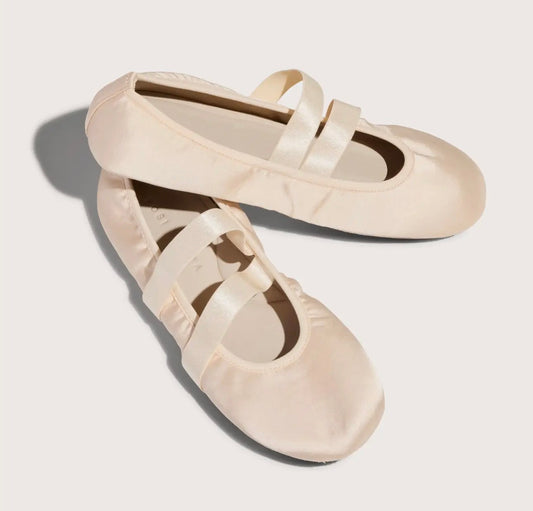 Pair of beige ballet flats on a light background